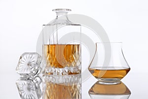 Bottle and glass of brandy on a white table