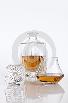 Bottle and glass of brandy on a white table