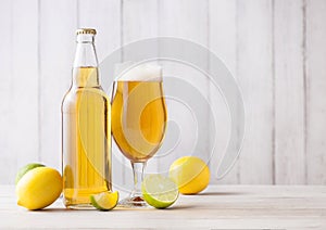 Bottle and glass of lager beer with lemon and lime