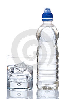 Bottle and glass of mineral water with droplets