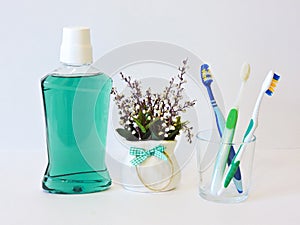 Bottle and glass of mouthwash on bath shelf with toothbrush. Dental oral hygiene concept. Set of oral care products