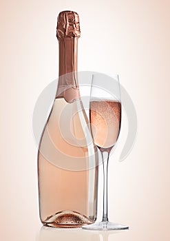 Bottle and glass of pink rose champagne on pink