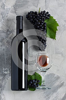 Bottle and glass of red wine grapes with leaves