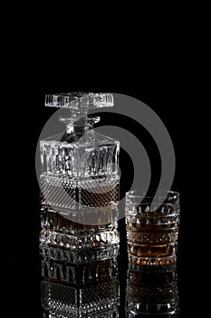 Bottle and glass of scotch on a dark background