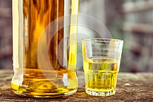 Bottle and glass shot with yellow liqour