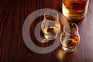 Bottle and glass of whisky spirit brandy on dark brown background