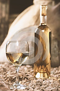 Bottle and glass of white wine .