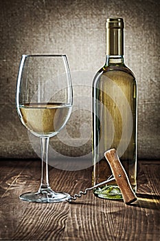 Bottle and glass with white wine and corcksrew