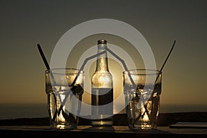 Bottle and glasses. Backlight at sunset photo