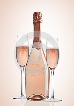 Bottle and glasses of pink rose champagne on pink