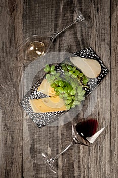 A bottle and glasses of red and white wine with fruits