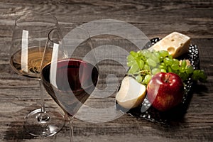 A bottle and glasses of red and white wine with fruits