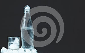 Bottle with glasses of vodka on black background