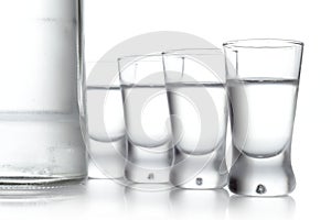 Bottle and glasses of vodka isolated on white