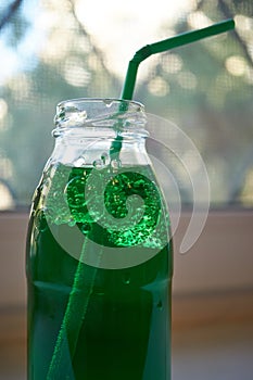 Bottle of green aerated water with straw
