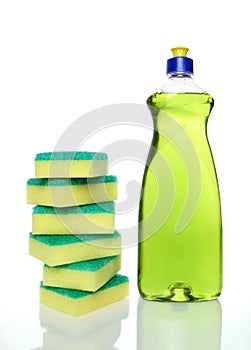 Bottle of green dishwashing liquid and sponges