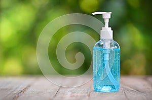 Bottle of Hand sanitizer blue gel alcohol on wooden table