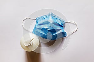 Bottle of Hand sanitizer and Face Mask on white background