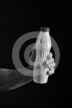 Bottle with healthy drink or yoghurt in hand of man