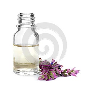 Bottle of herbal essential oil and sage flowers isolated