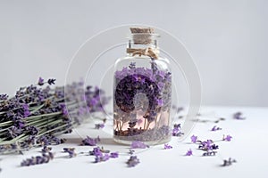 Bottle with herbal natural lavender oil and flowers on a white background