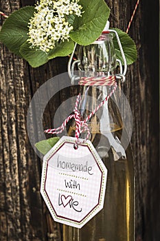 Bottle with homemade elderflower syrup on a wood truss