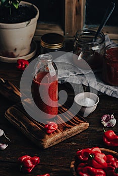 Bottle of Hot Chili Sauce with Habanero Peppers, Charred Bell Peppers and Tomatoes