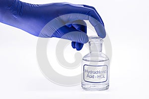 Bottle of hydrochloric acid, handling with glove for chemist, chemical solution used in the industry in general, toxic and