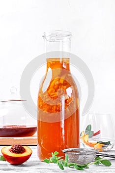 Bottle of iced tea with nectarine, peach and lemon