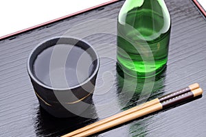 Bottle of Japanese shochu and bowl on wooden tray