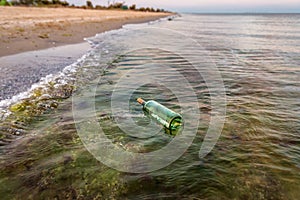 Bottle with letter in the water near the beach