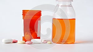 bottle with liquid medicine and pills on white