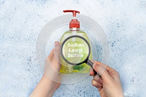 A bottle of Liquid soap floating in soapy water. Harmful ingredients, detergent with Sodium Lauryl Sulfate. The concept of