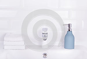 Bottle of liquid soap and stack of towels. Toiletries, towel and soap. Home background bathroom