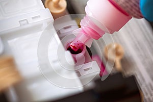 Bottle with magenta colour ink refilling printer cartridge