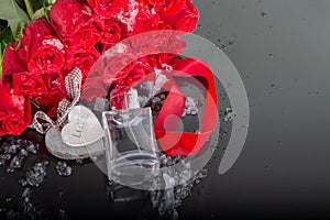 Bottle of mens and perfume and wooden hearts with red roses on a mirrored dark background with water drops. Presentation