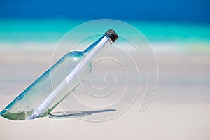 Bottle with a message buried in the white sand