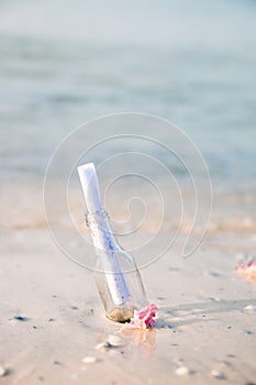 Bottle with a message or letter on the beach. SOS. Copy space. Help.