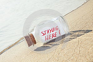 Bottle with a message staying here on sandy beach