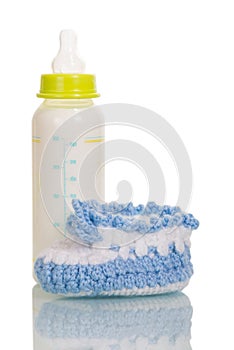 Bottle with milk and baby's bootee photo