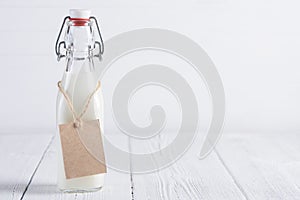 Bottle of milk with blank paper tag on rope