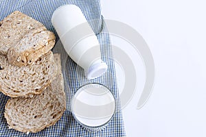 A bottle of milk and glass of milk with sliced bread on cloth indoors background for food and healthy concept. with copy space for