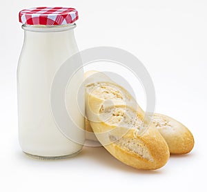 Bottle of milk and loaves of bread baguettes, Copy space. Front view. Isolated on white background