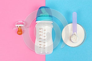 Bottle of milk for newborn baby, pacifier on a pink background and jar with powdered infant formula on blue background