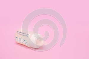Bottle of milk for a newborn on a pink background
