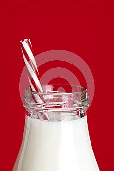 Bottle of Milk with Straw over Vibrant Red Background