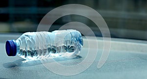 a bottle of mineral water on the dashboard of the car. Bottled water was left in the car for a long time