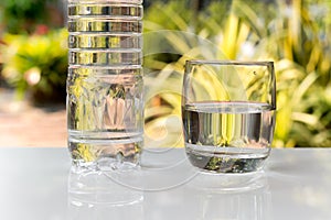 Bottle mineral water and glass with water on white table