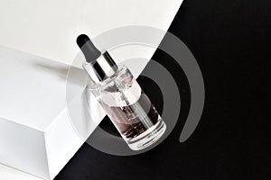 Bottle of moisturizing face oil on a white-black background. A professional product for the perfect complexion. Women`s accessorie