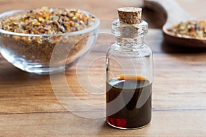A bottle of myrrh essential oil with myrrh resin in the background